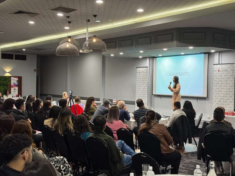 Trang delivering a corporate workshop to an engaged audience in a lecture hall. 
