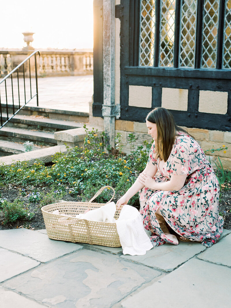 A mother reaching reaching down to her baby in a basket by Katie Stansfield Photography, a Richmond family photographer.