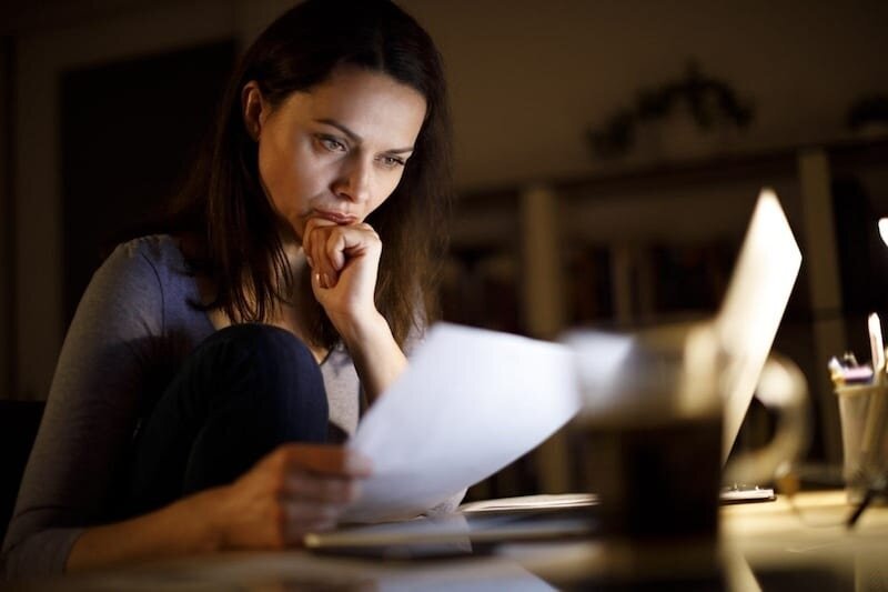 dark-haired architect is stressed reviewing papers