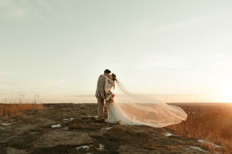 bride and groom kissing on a mountain
