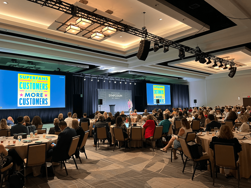 Wide shot of audience members who are watching Brittany Hodak speak about creating superfans in the real estate industry for Keller Williams Luxury Symposium