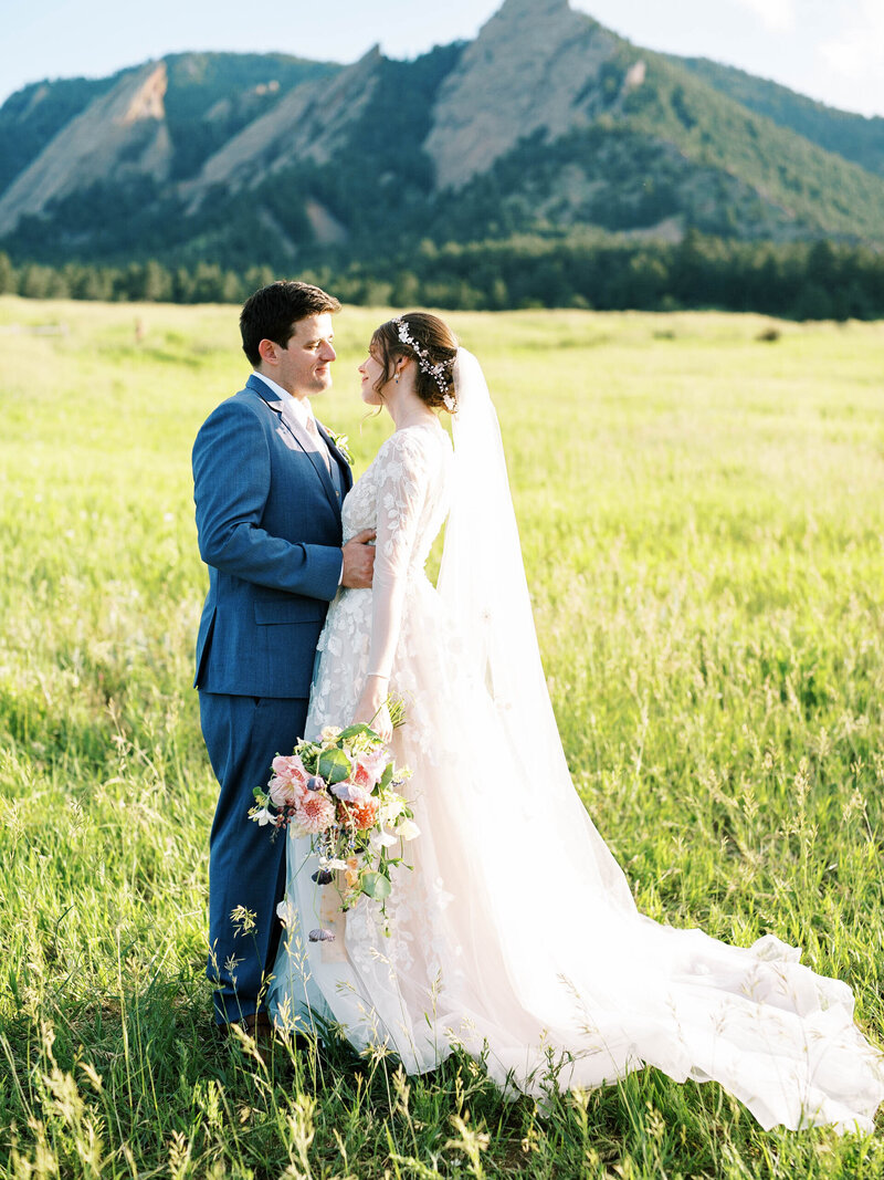 bride and groom who is wearing a blue tux looking at each other at  chautauqua park by Colorado Wedding Photographer JKG Photography