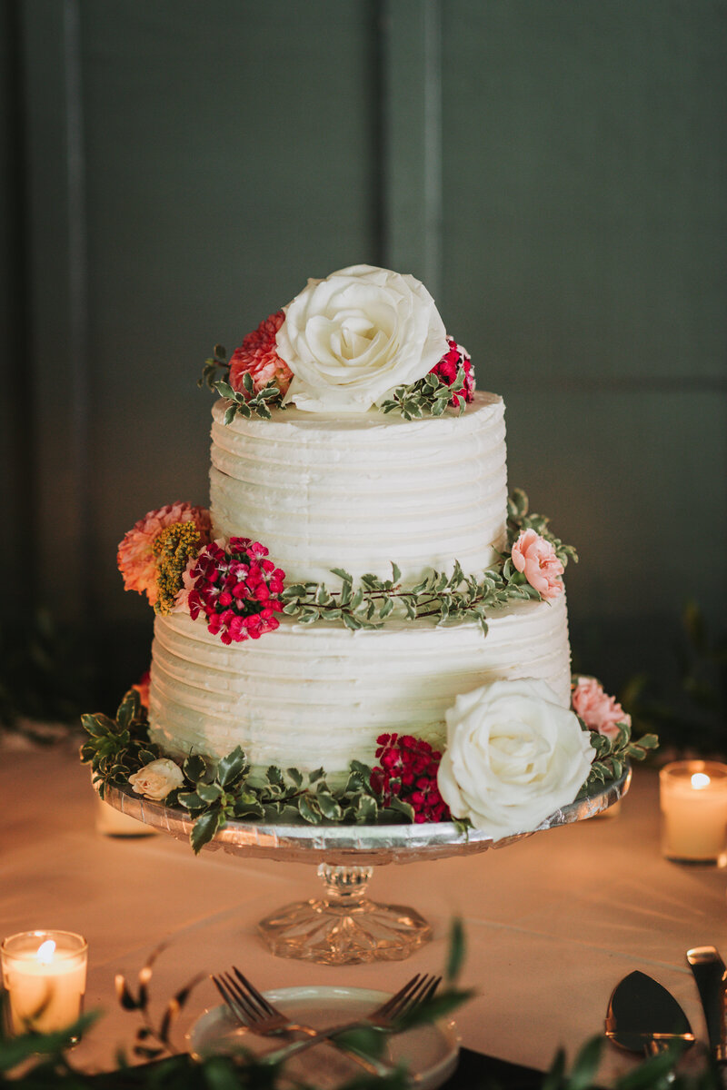 White wedding cake with red and white flowers at the Gandy Dancer