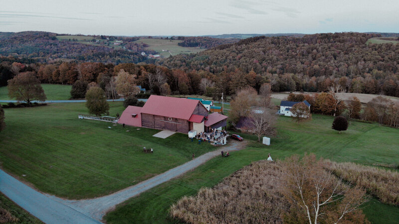 Aerial view of a rustic barn wedding venue with surrounding fields in Catskills, NY.