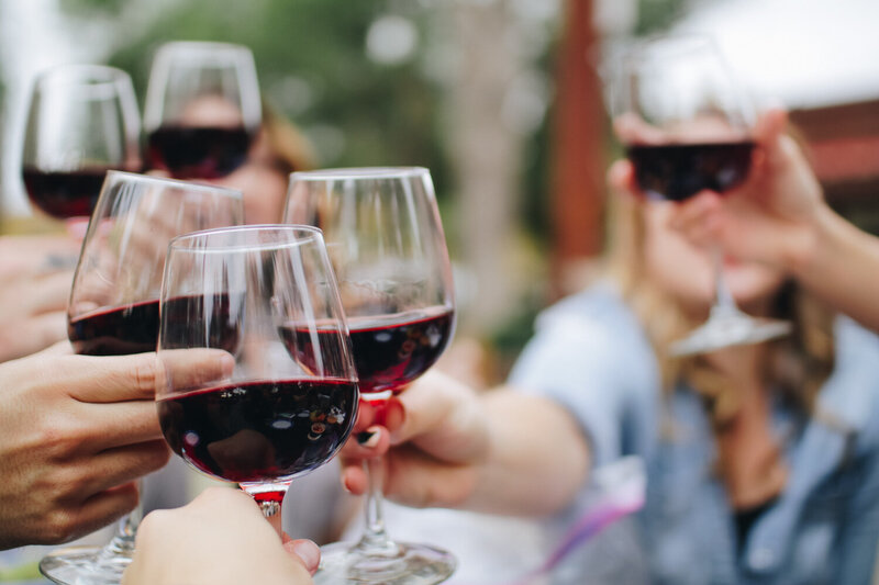 Wine glass filled with red wine toasting