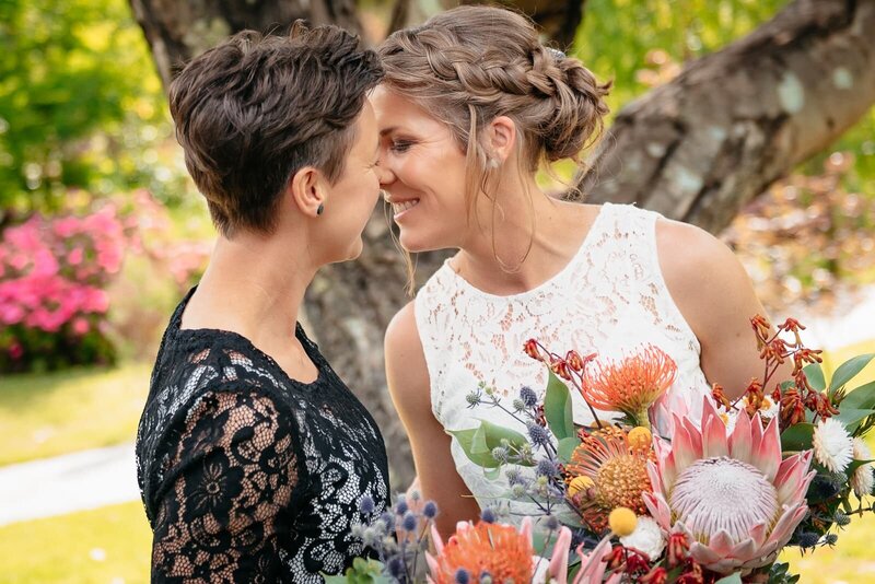 Zoe & Emma sneaking a kiss after their wedding ceremony at Willow Glen Gardens, Ballarat VIC