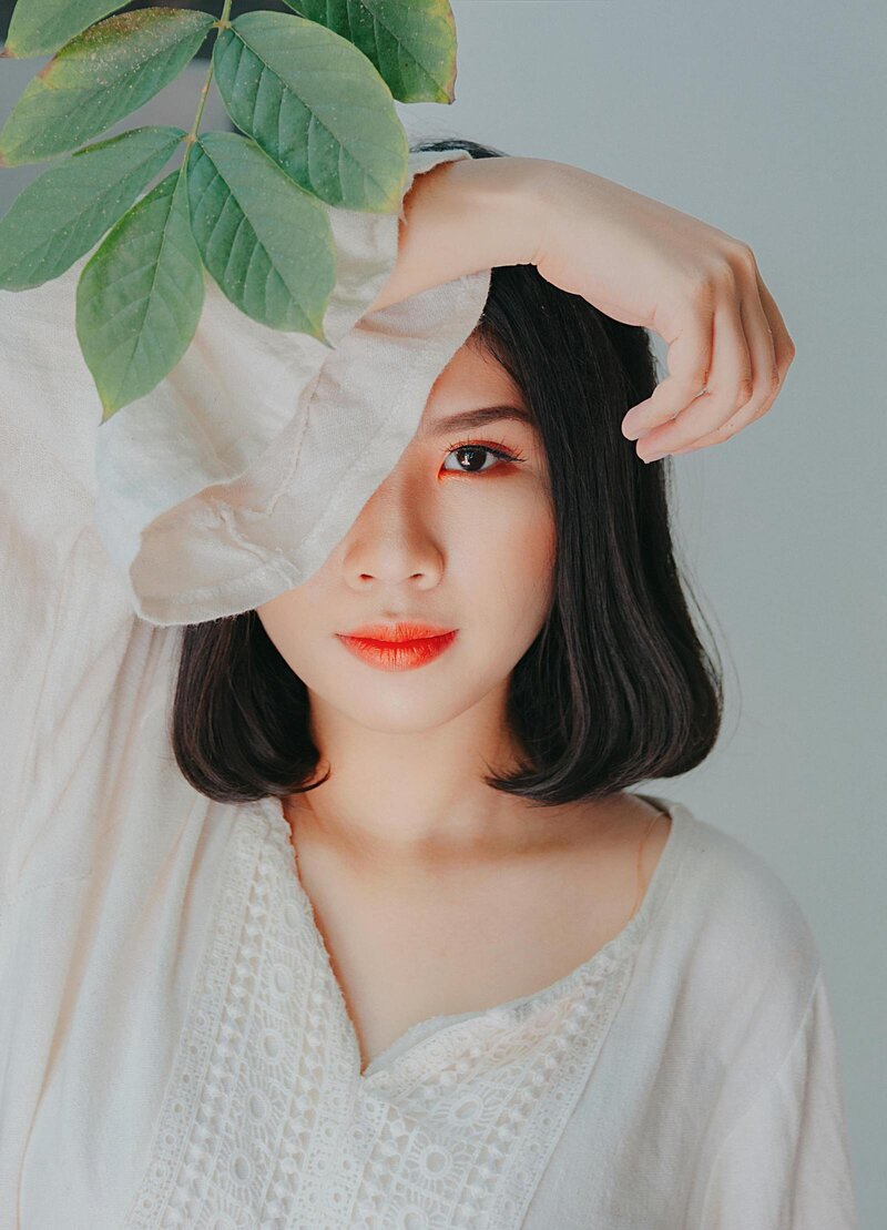 woman with leaves and sleeve over her face