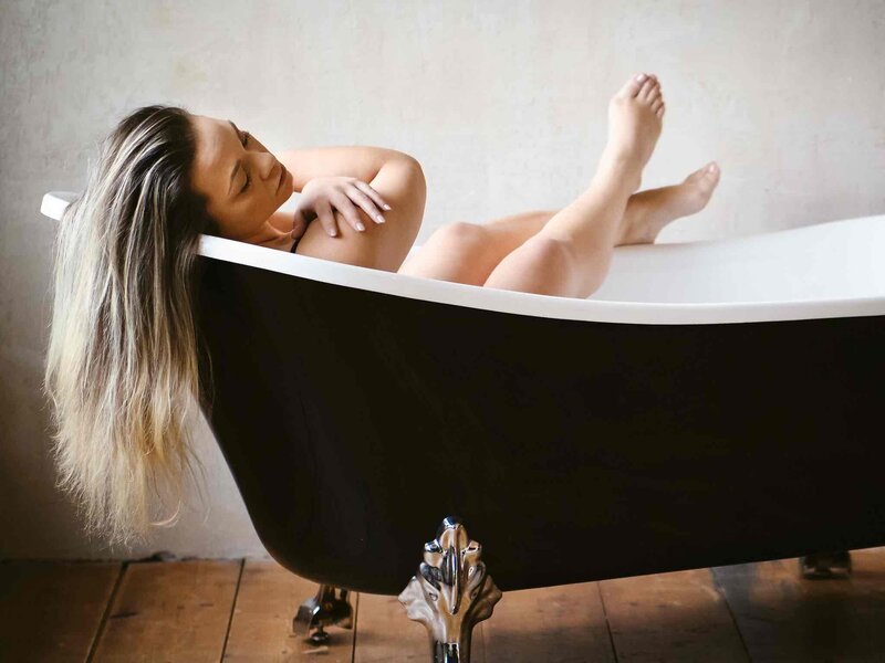 Elegantes Boudoir-Bild: Frau mit sanftem Lächeln und femininer Haltung