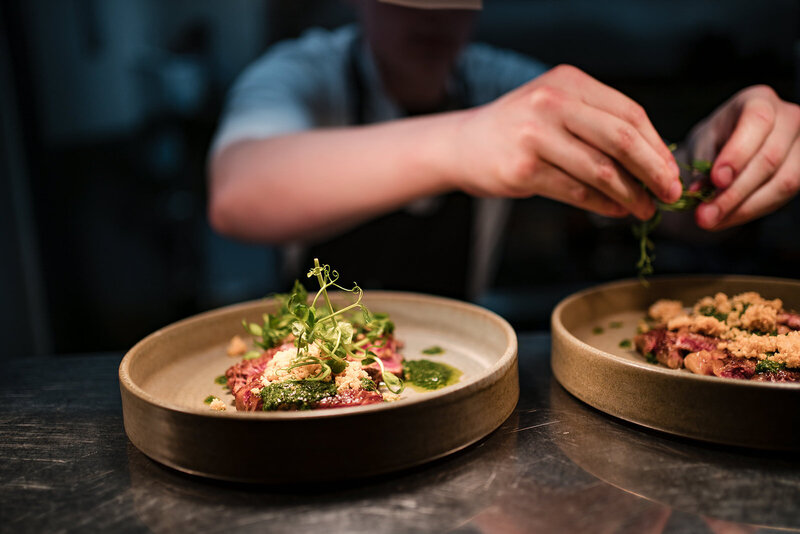 Chef hands serving up the finishing touches to compamigos tapas 