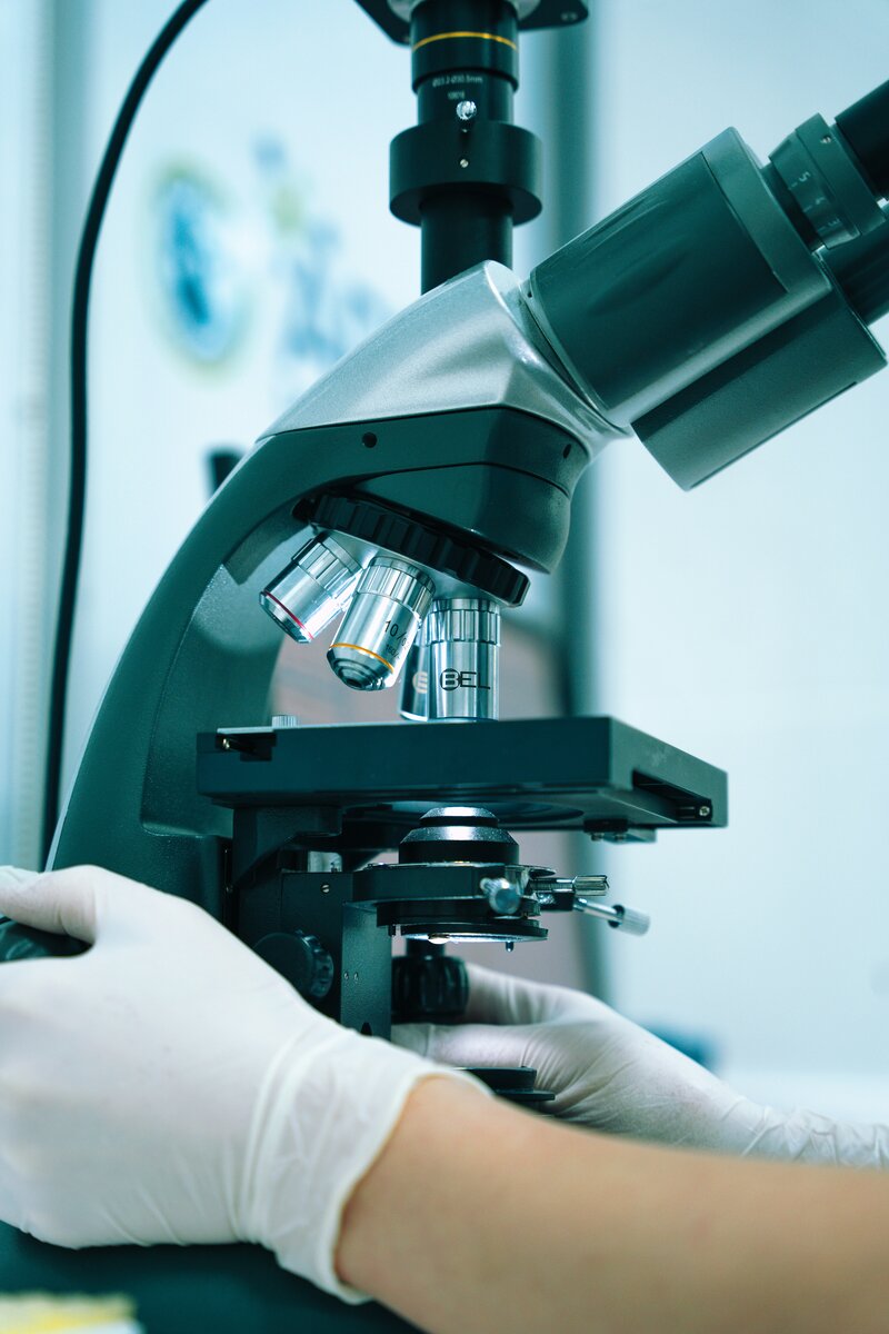 lab technician examining blood sample under a microscope