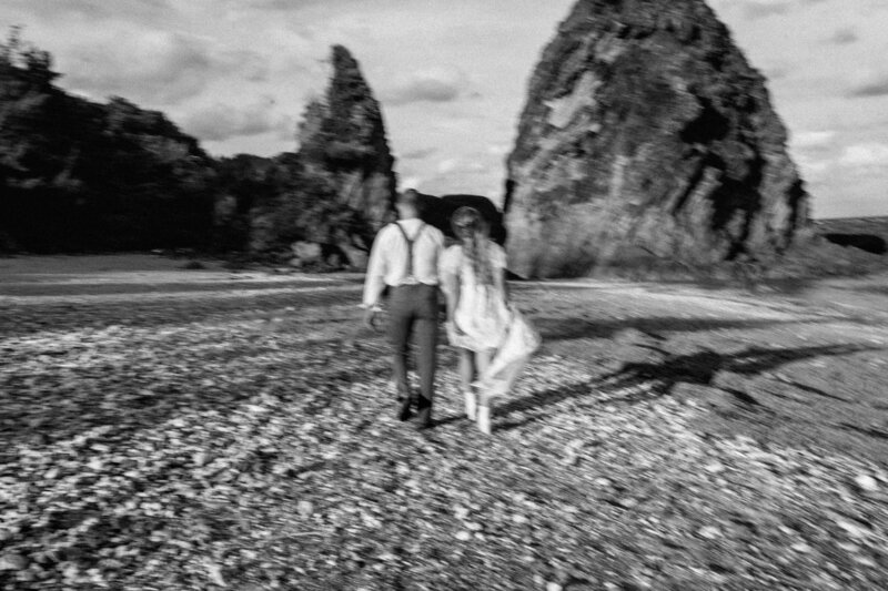 a blurry image of M & J running on the beach towrads the rock formations putting out of the ocean