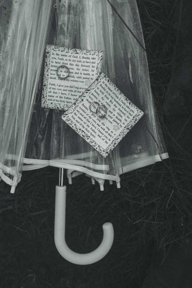 rings and vows under clear umbrella