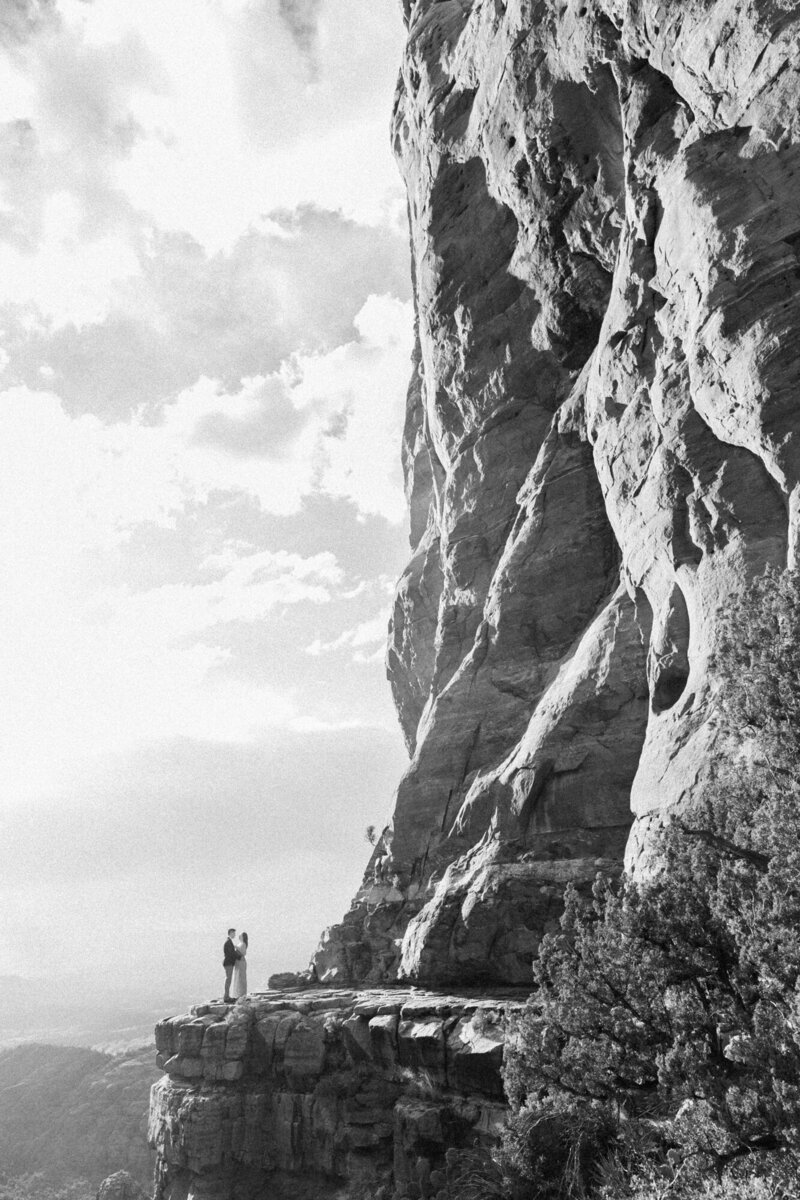 A black and white Sedona engagement photo captured at sunset at Cathedral Rock