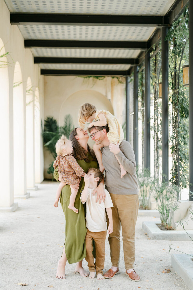 Family of five poses outside of the National Bank in Philly during a family photo session with AnneMarie Hamant