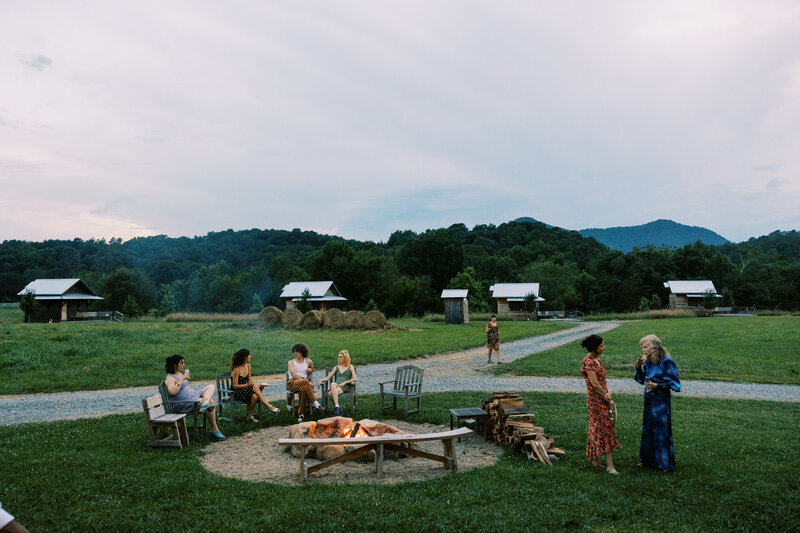 Wedding guests enjoy the firepit outside their on site lodging at wedding venue Paint Rock Farm in North Carolina, by photographer Megan Lynn of My Sun and Stars Co.