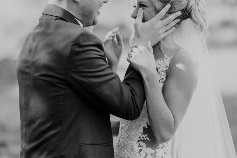 bride crying and groom wiping away tear during first look at knoxville wedding