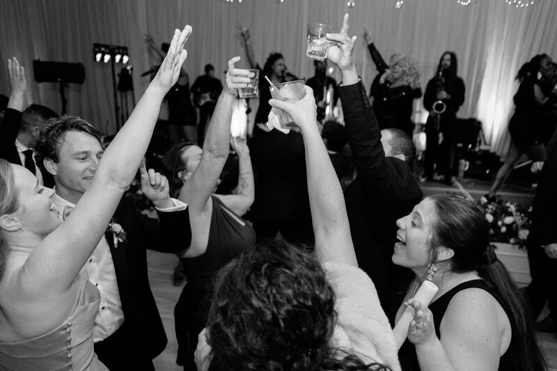 November wedding at Graylyn Estate, designed and planned by Charming Carolina — bride and groom toasting with friends on the dance floor during the reception in the Atlantis Room.