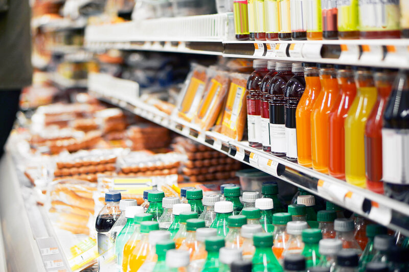 A static image of a convenience store display cooler with drinks and food