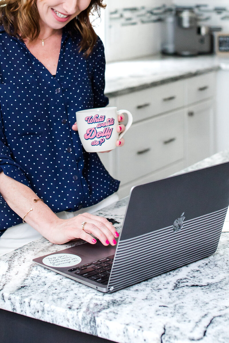 Flatlay of coffee mug with coffee next to an iphone and pink earrings