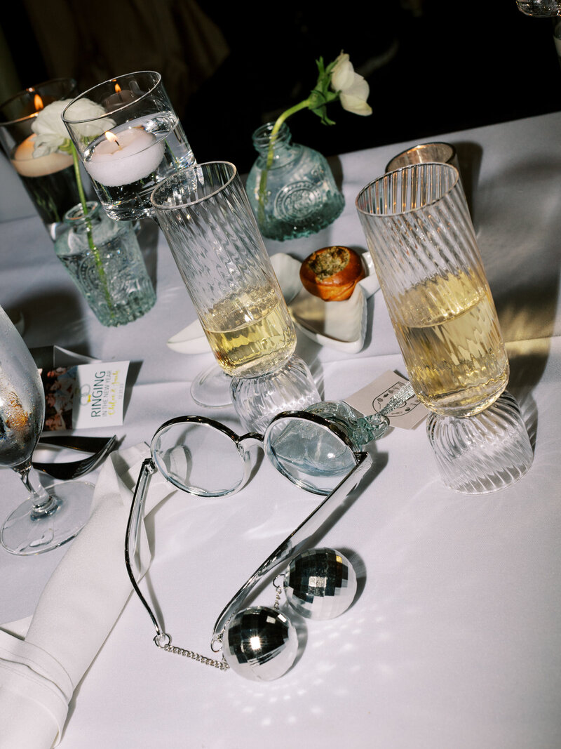 flash photo of table at reception with champagne glasses and disco balls