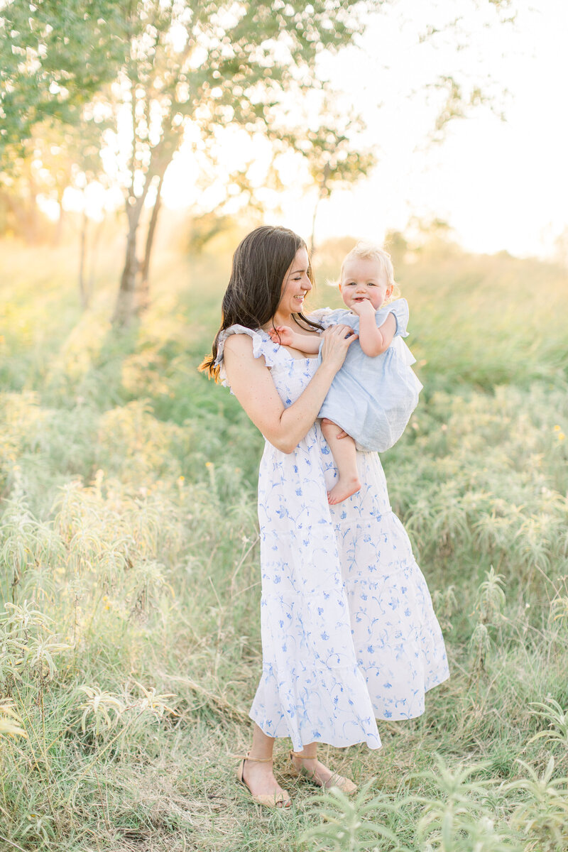 Family portrait in Oklahoma with mother in blue and white dress holding child