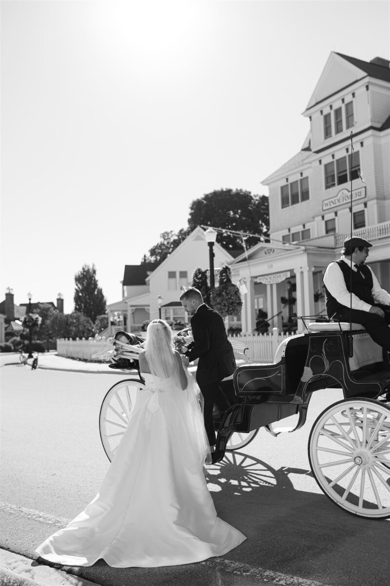 Mackinac Island Couples photo of groom helping bride into carriage