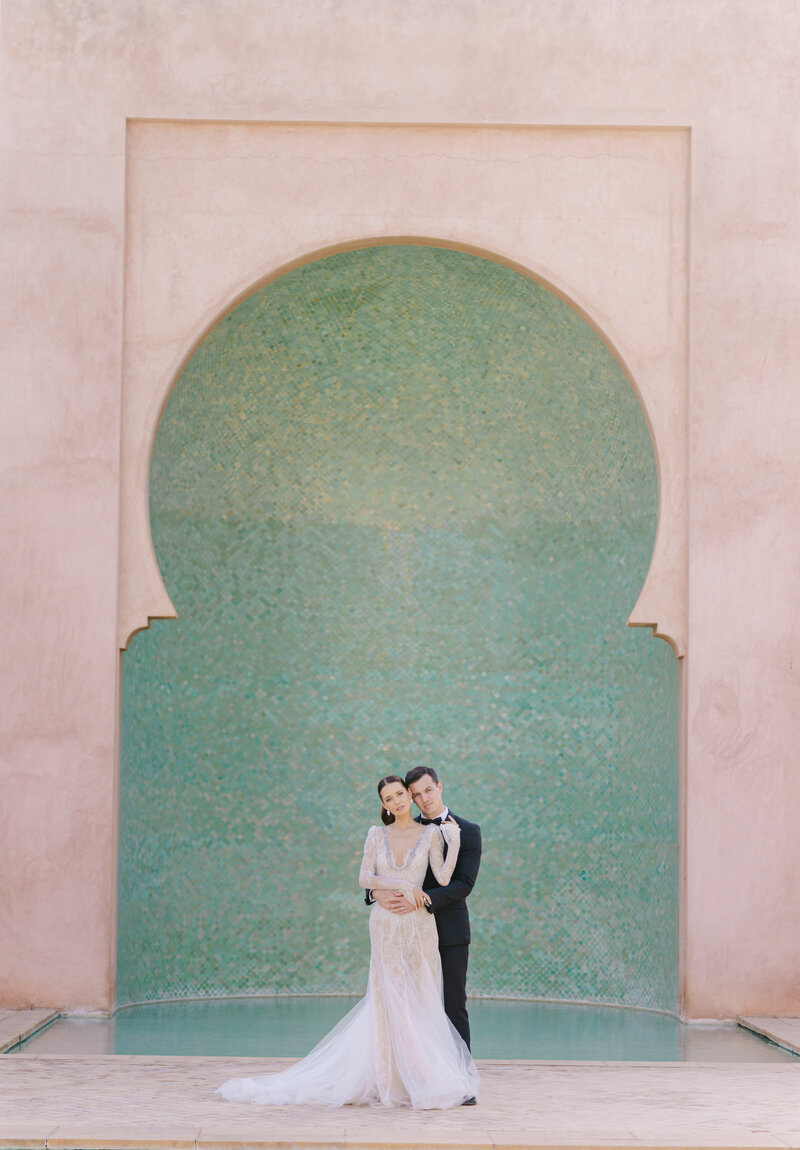 Bride and groom in front of turquoise arch
