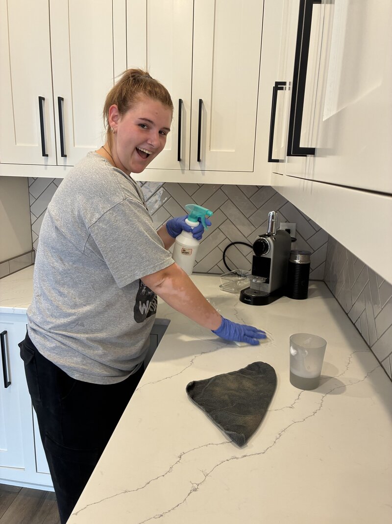 Co-founder scrubbing a countertop during a residential deep clean