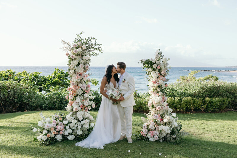 Maui Elopement Photographer captures woman standing on rocks holding camera