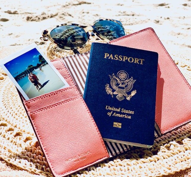 passport with sunglasses and small photo on sand