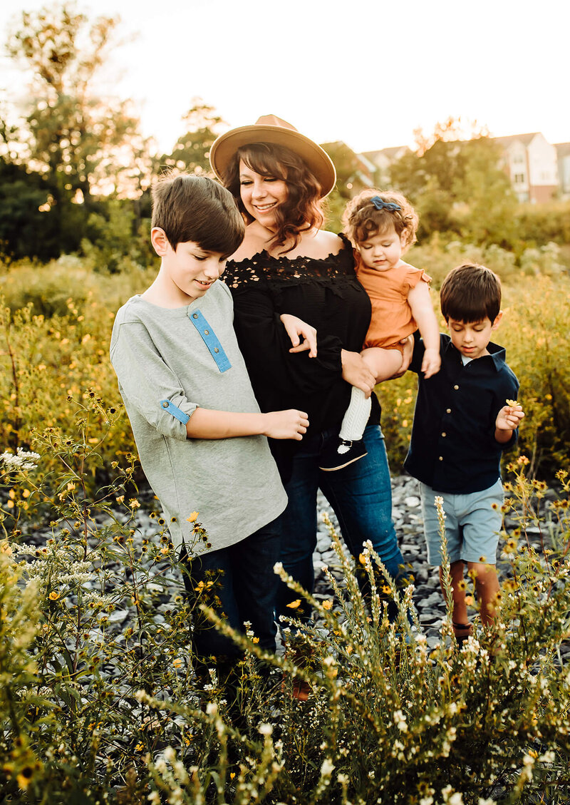 Women in brown hat and black shirt with three children in a field of yellow flowers near Hanover Maryland