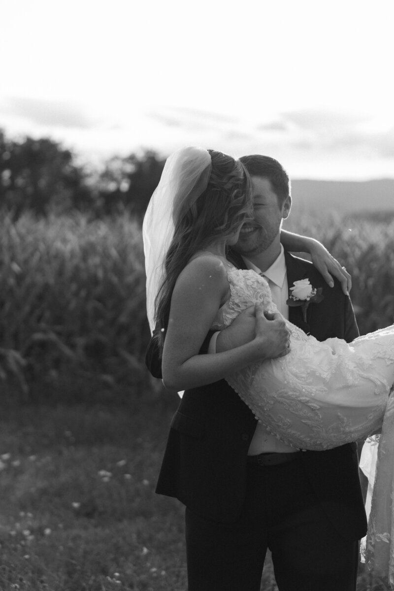 groom-carrying-bride-laughing-black-and-white