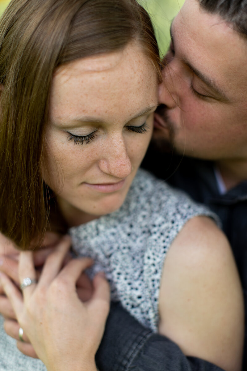 Liz and Eric snuggle close while Eric kisses Liz's cheek