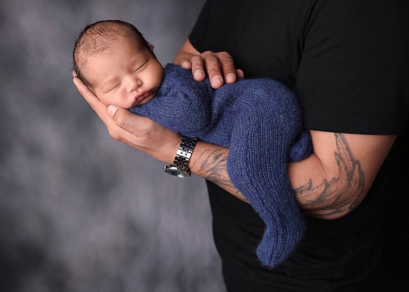 Newborn sleeping in his Santa hat in a present at his denver baby photography session.