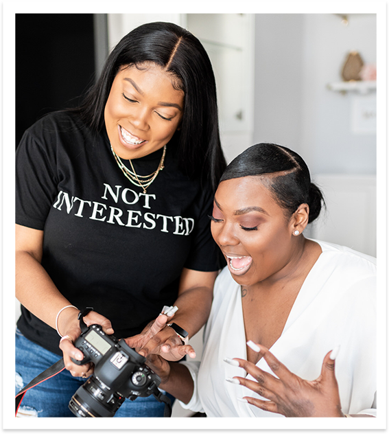 black woman showing another excited black woman a photo on her camera