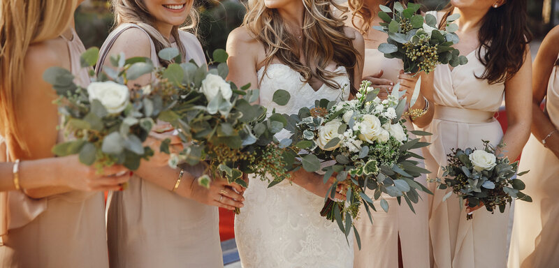 bride-and-bridesmaids-with-pastel-bouquets-stand-side-by-side
