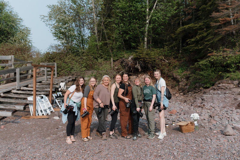 A group of photographers standing together on a hiking trail 