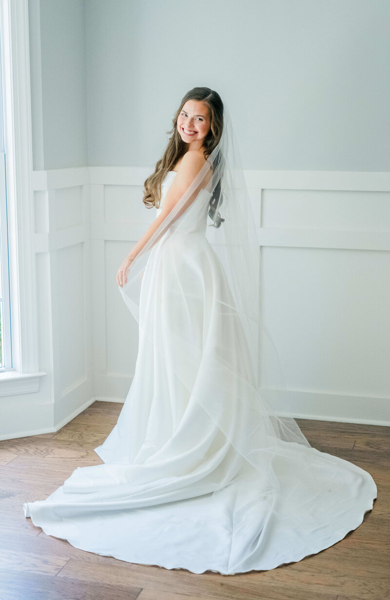 Bride standing in room wearing wedding dress for bridal portraits