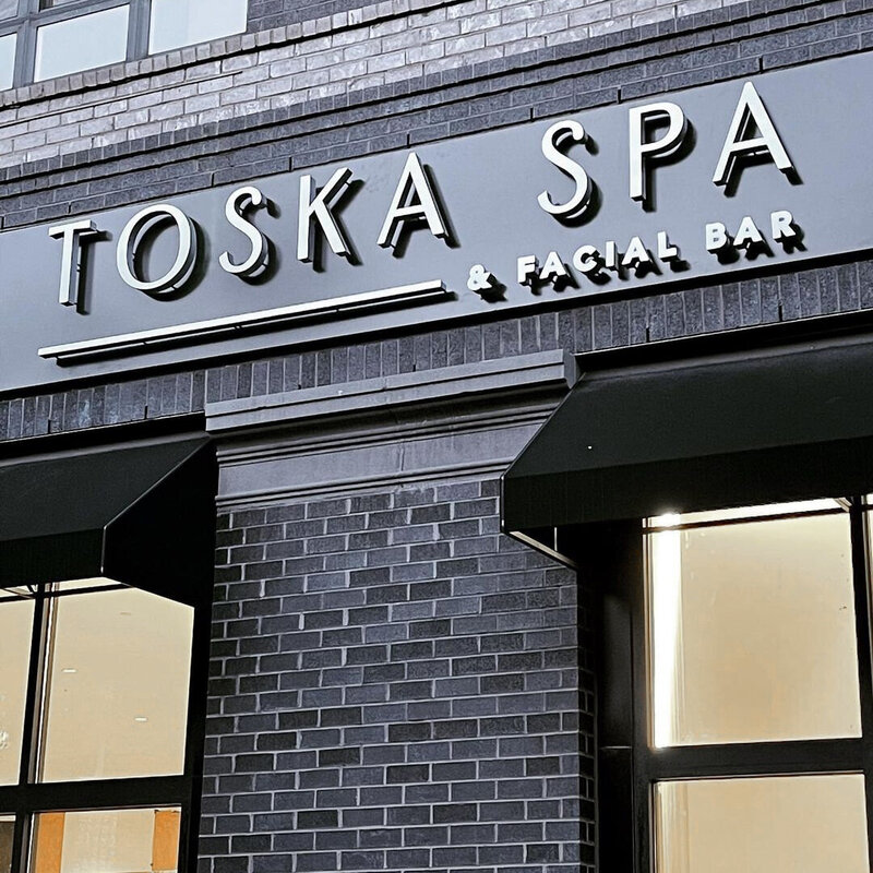 Exterior signage at Toska Spa’s Charlotte location featuring minimalist brand design