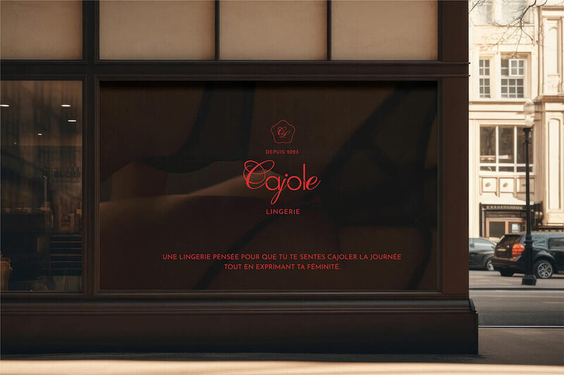 Maquette de présentation de l'identité visuelle de Cajole Lingerie, qui représente l'ambiance confortable et ensoleillée des matins au lit. L'image montre un panneau publicitaire et le logo vertical et le slogan de la marque.