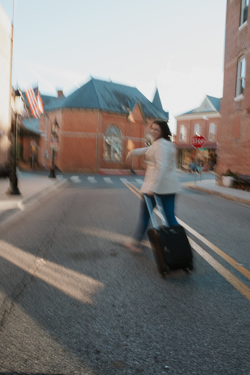 Cassie with a Suitcase Walking Down Road