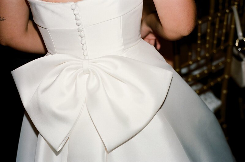 detail of big bow on the back of brides wedding dress 