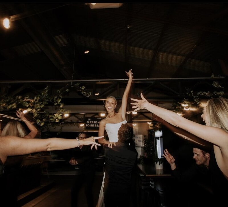 Bride lifted by the bridal party, highlighting the creativity and spirited environment fostered by LIMCO’s dance lessons.