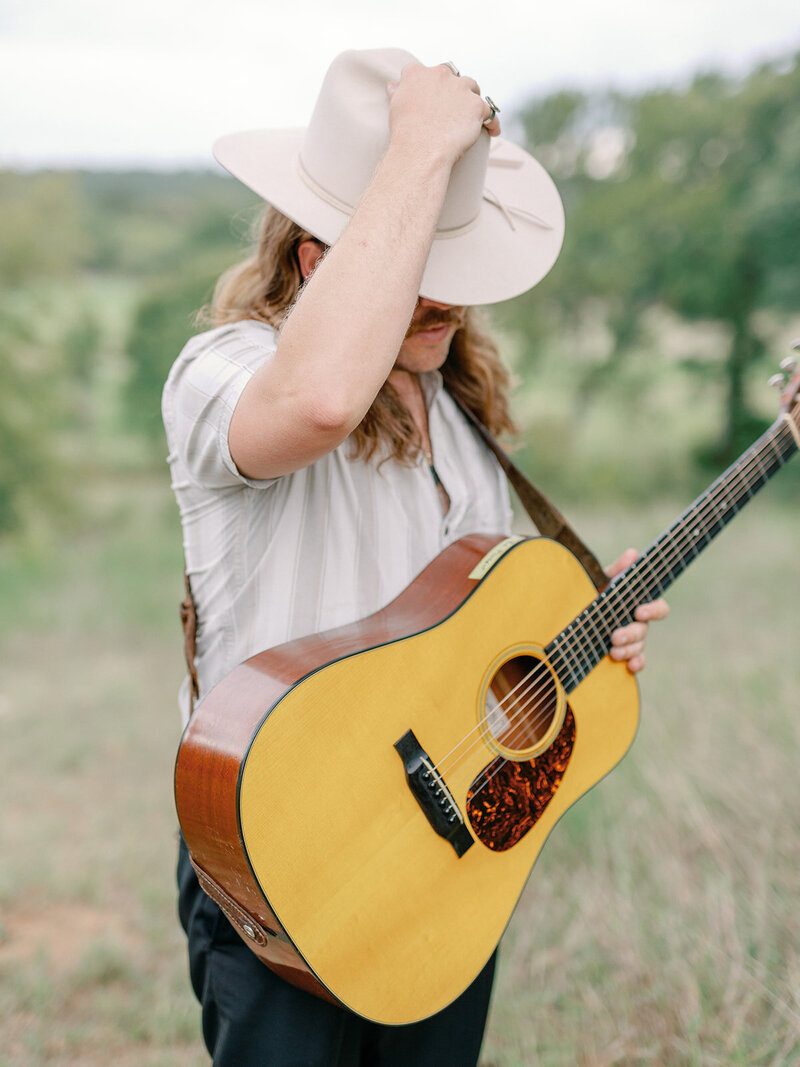 Mikaela Kahn's husband Jordan holding a guitar