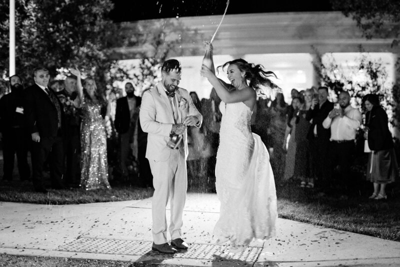 Bride pops champagne during grand exit on wedding day at Deerfield Country Club