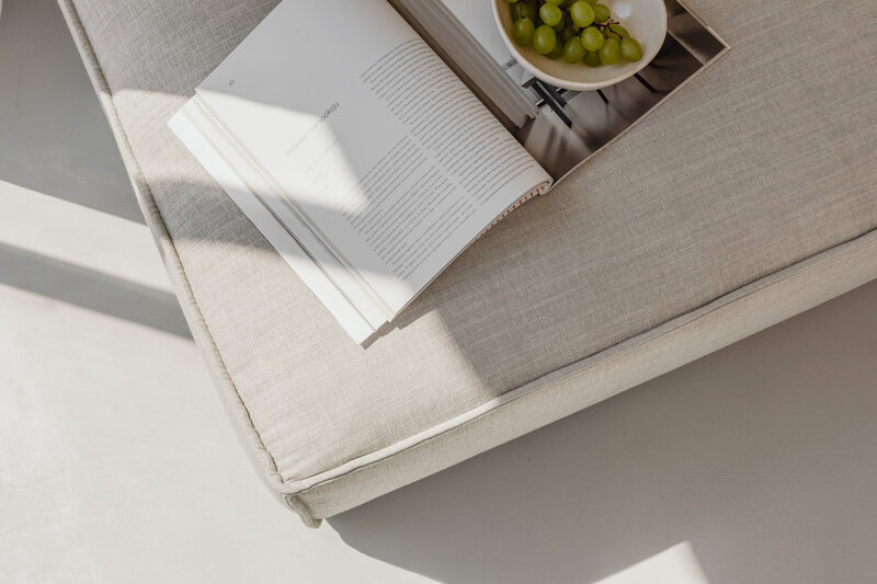 Aufgeschlagenes Buch auf einem beigen Sofa