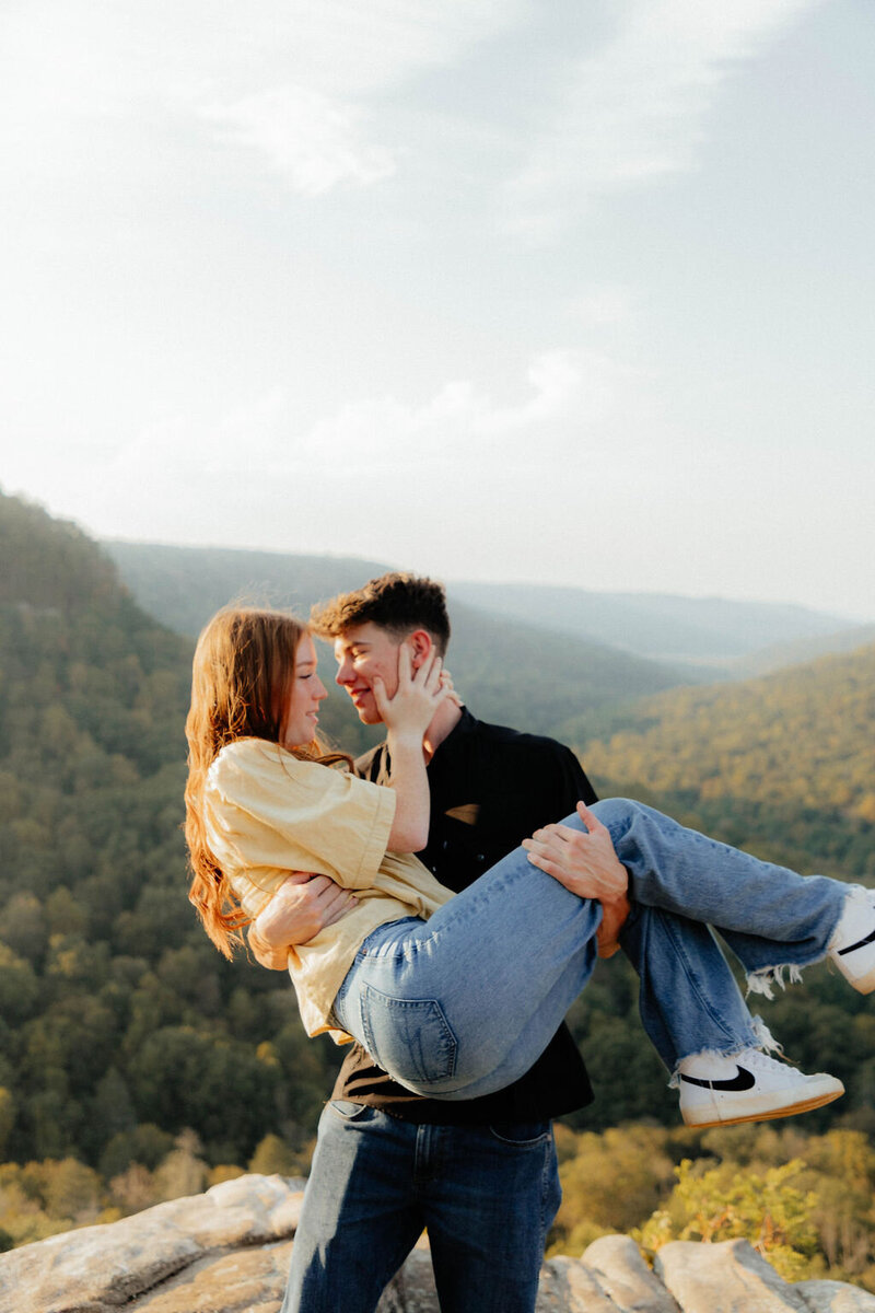 man holding woman in mountains