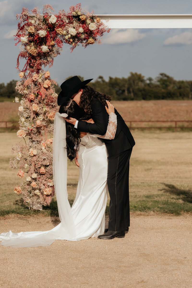 bride and groom kissing at alter