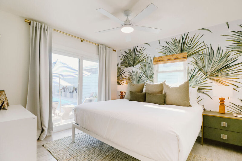 bedroom with King bed, white linens, green pillows, and green night stands