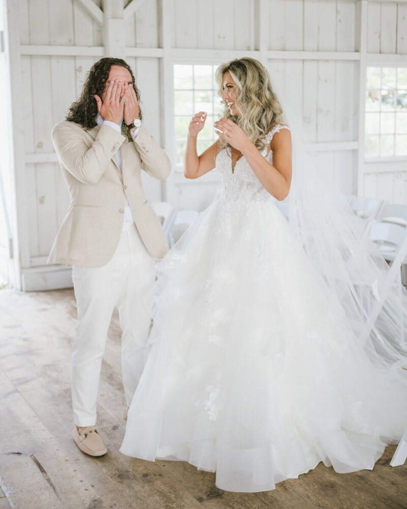 A groom covers his face in shock as he sees his bride for the first time during their first look at Bonnet Island Estate